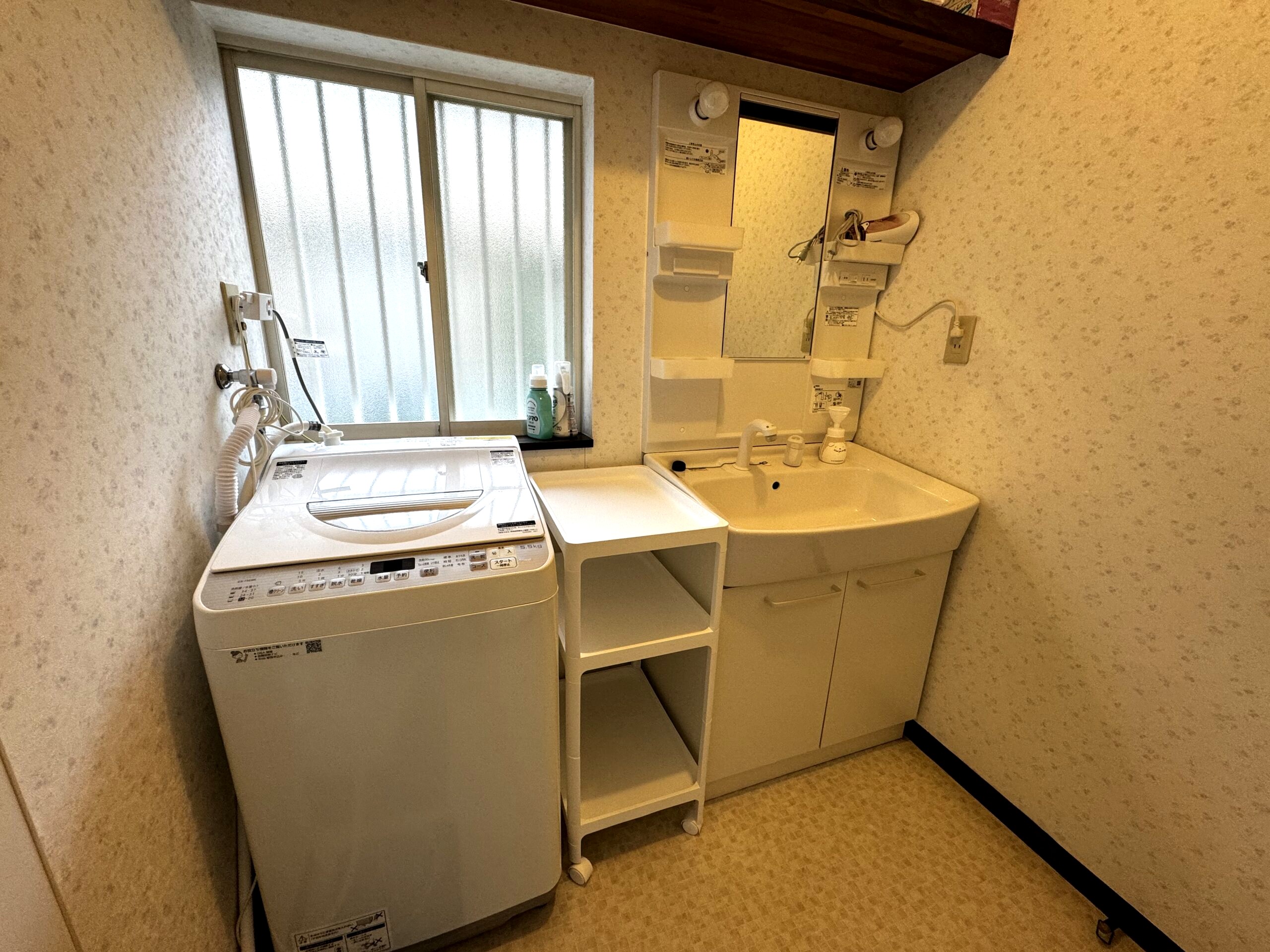 にこにこビレッジ桜ヶ丘の洗面所。洗面化粧台と洗濯機