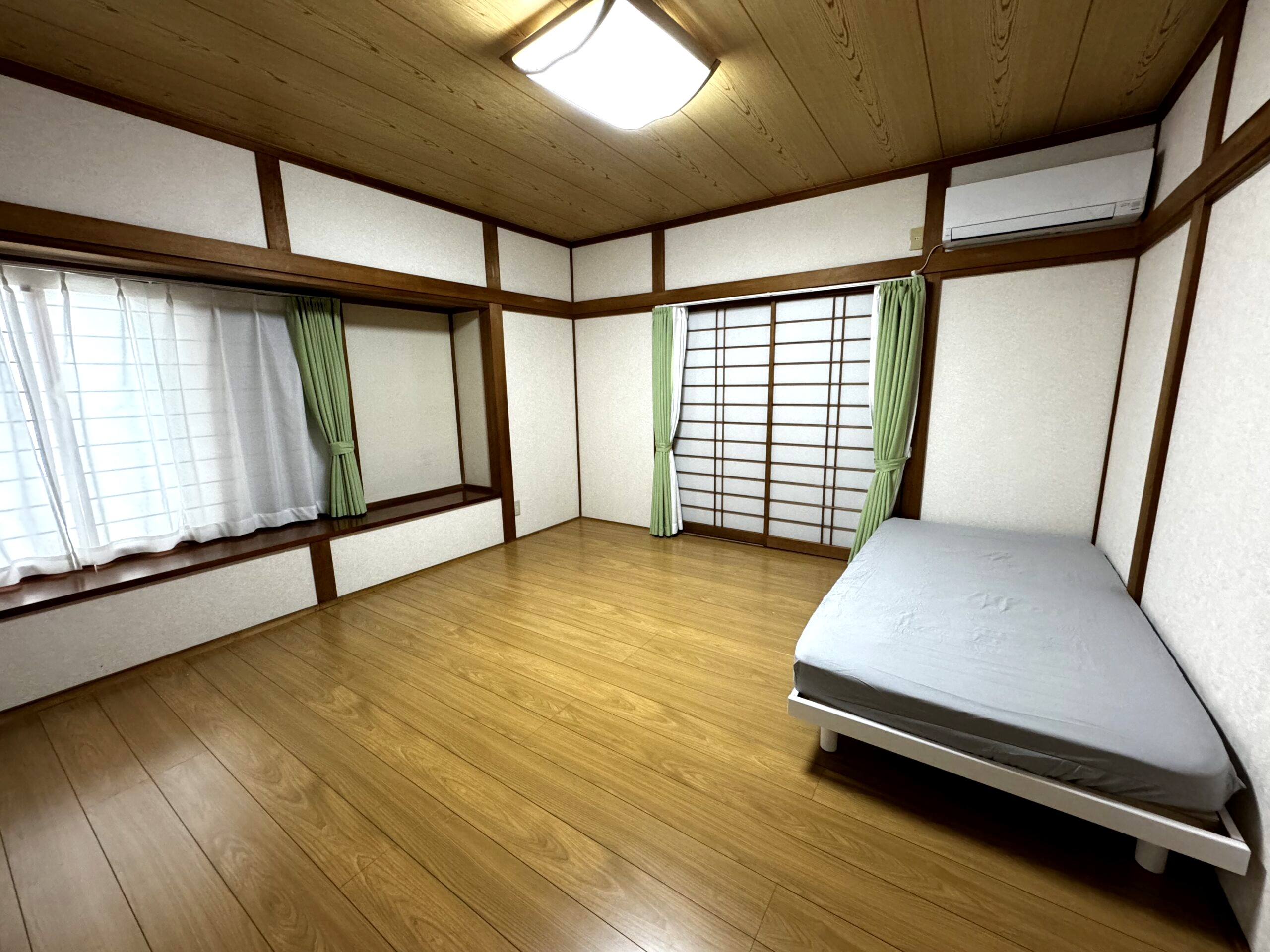 にこにこビレッジ桜ヶ丘の居室。木目の天井と障子のある明るい和室風の部屋にベッドを設置